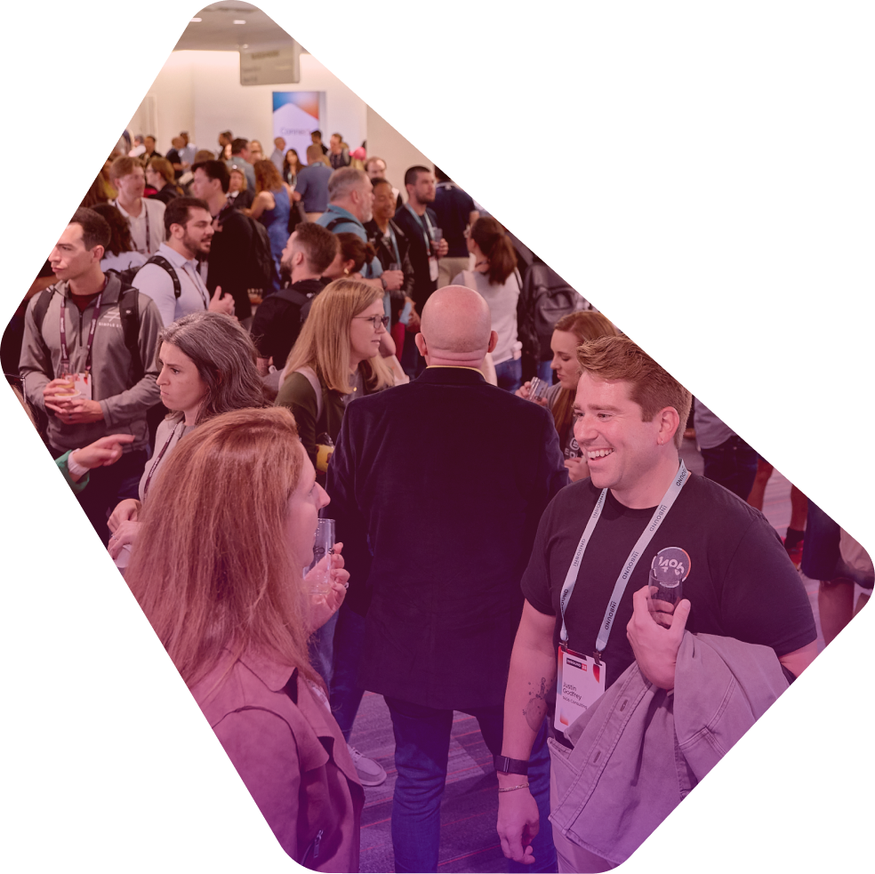 Crowded networking event with attendees in business attire socializing and holding drinks