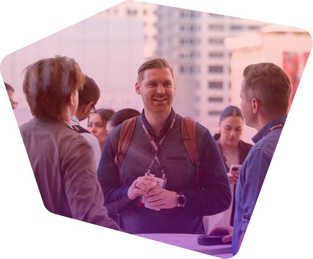 Smiling man with conference badge networking with colleagues at outdoor event