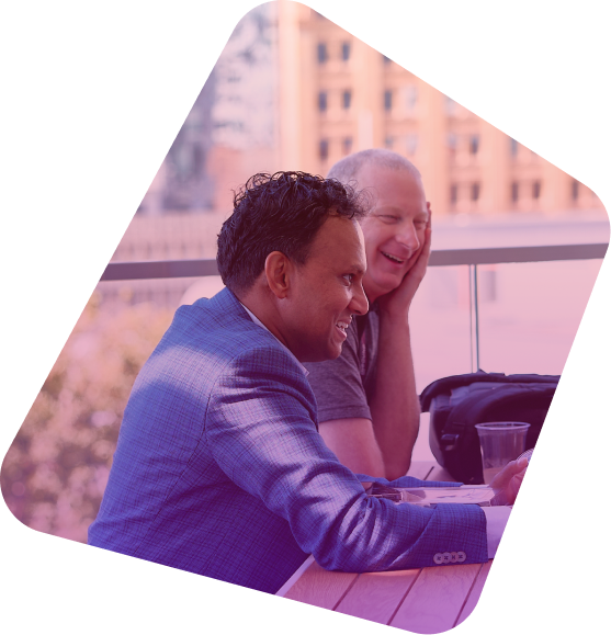 Two business professionals smiling while looking at a laptop