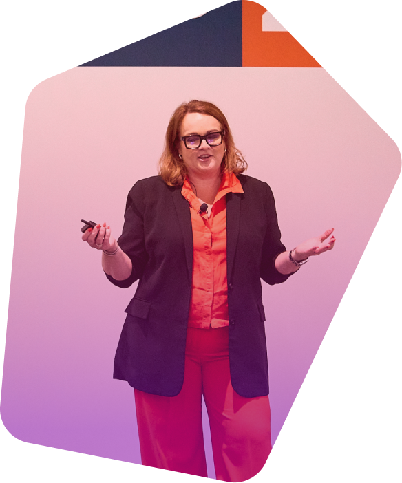 Professional woman in dark blazer and orange shirt presenting with gesturing hands