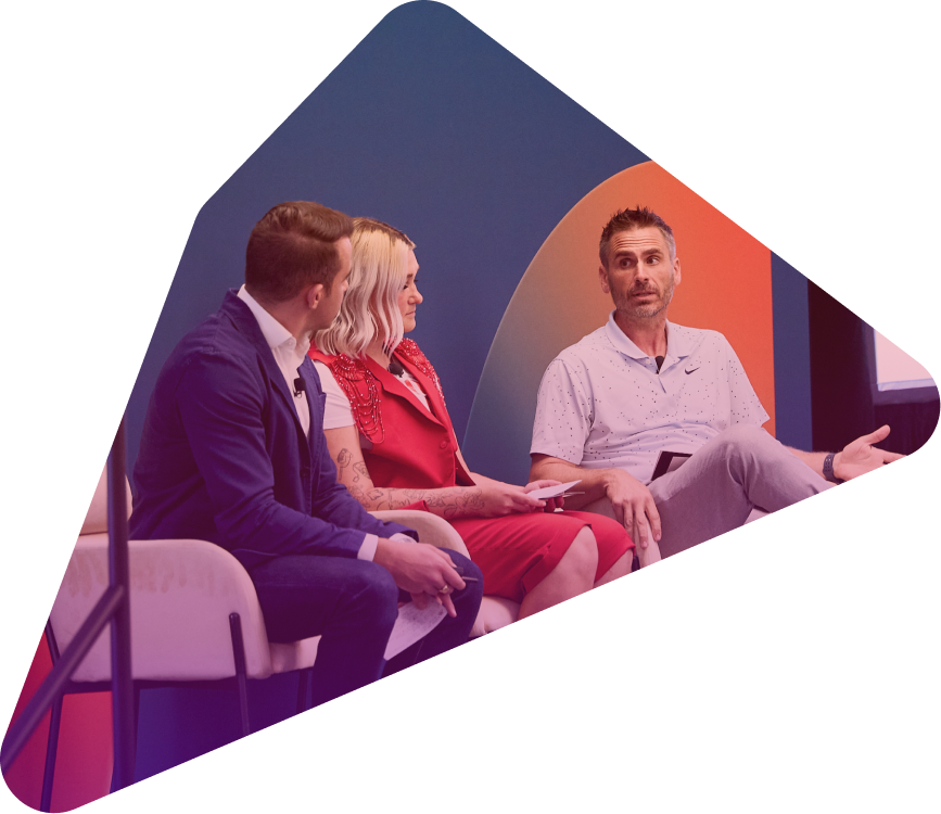 Three people sitting and having a conversation at a conference or panel event