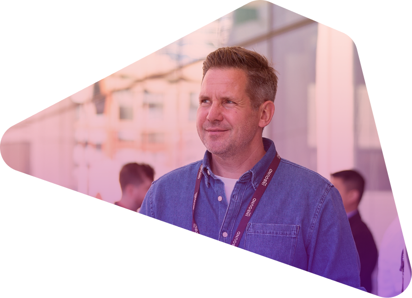 Man in blue shirt with lanyard smiling at conference event