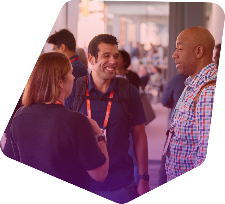 Three diverse professionals networking and smiling at a conference event
