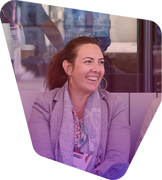 Professional woman in gray blazer smiling during conference presentation