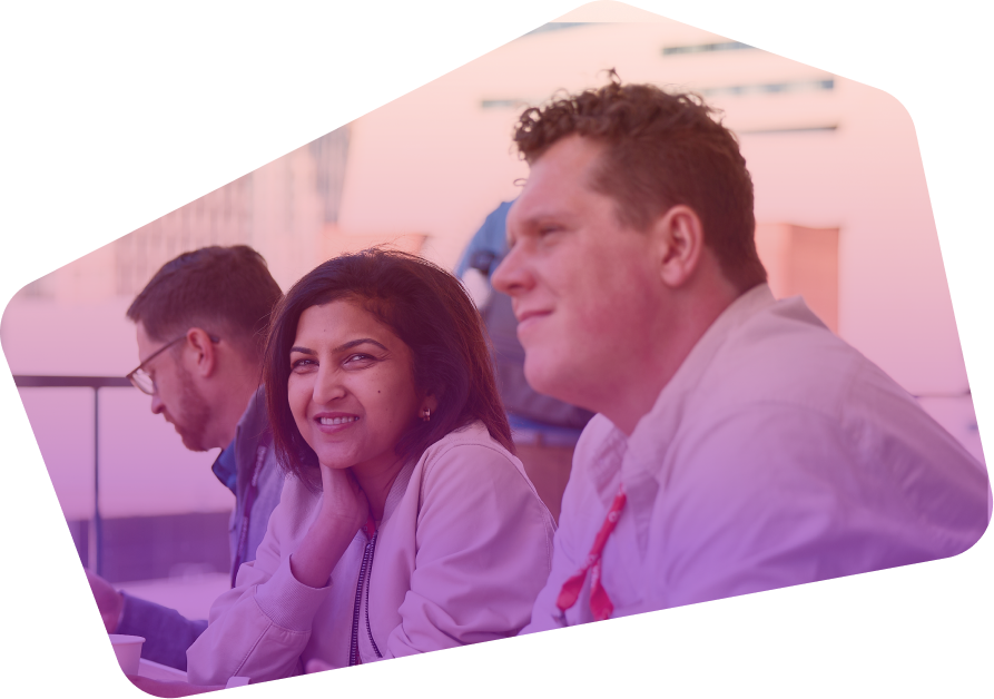 Three professionals sitting and smiling during a conference or business event
